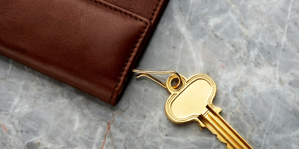 Braunes Lederschlüsseletui, goldener Schlüssel, Marmoroberfläche, Accessoires, Damen und Herren