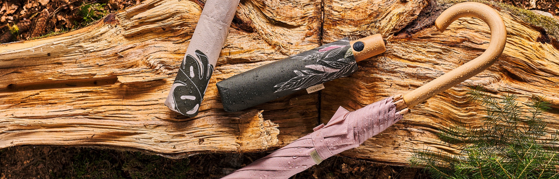 Doppler, Regenschirme auf Holzstamm, stilvoller Schirm, Modeaccessoire, Lifestyle-Foto, Trendaccessoire, Outdoor