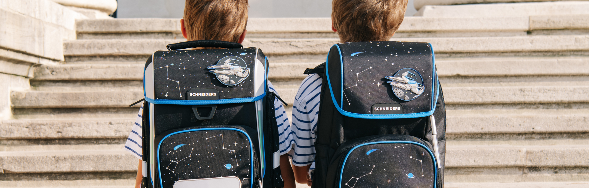 Schneiders, zwei Kinder mit Schulranzen auf dem Rücken, Rückenansicht, Stufen im Hintergrund